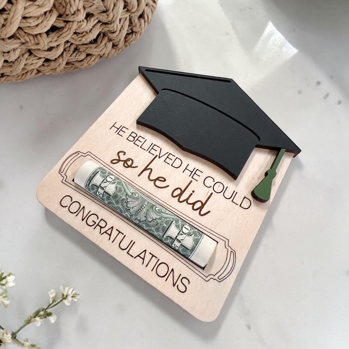Graduation-themed money holder with a cap on a light surface