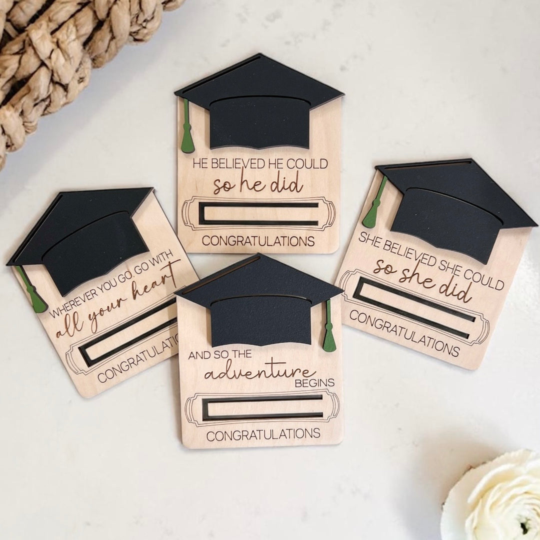 Graduation-themed wood money holders with mortarboard designs on a light background.
