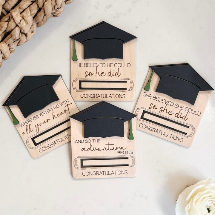 Graduation-themed wood money holders with mortarboard designs on a light background.